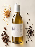 Aceite esotérico para masaje de 250 ml en botella de vidrio, rodeada de granos de café y pimienta