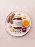 Frasco de miel fermentada Aumento de Líbido y Energía Sagrada sobre un plato con tamarindo, naranja y ajo