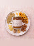 Frasco de miel fermentada Energetizante sobre un plato con flores de caléndula y canela